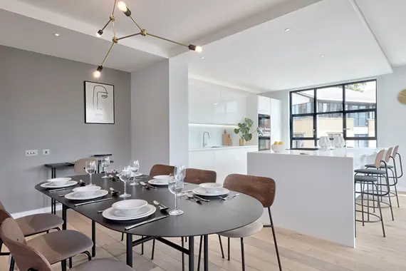 A spacious dining table and kitchen with amazing natural light