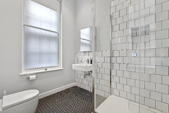 A polished and clean white tiled bathroom